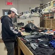 Un homme regarde un étalage de vêtement.