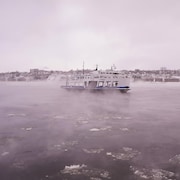 Un bateau sur le fleuve par temps très froid.