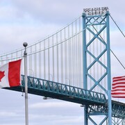 Les drapeaux canadien et américain flottent devant le pont Ambassador, qui permet de circuler de Windsor, en Ontario, à Détroit, dans le Michigan.