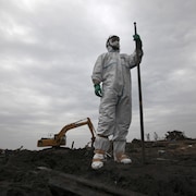  Un policier en combinaison de protection à Minamisoma, à environ 18 km de la centrale nucléaire endommagée de Fukushima, préfecture de Fukushima, le 11 avril 2011.