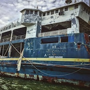 Un navire rouillé amarré dans un port.