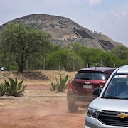 Des voitures devant une pyramide. 
