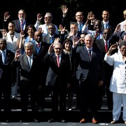 Les dirigeants des pays du G77 posent pour une photo de groupe, une main dans les airs.