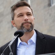Gabriel Nadeau-Dubois et Haroun Bouazzi devant une école.