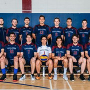 Des joueurs de volleyball posent pour une photo officielle, en deux rangées, dans un gymnase.
