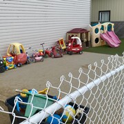 Des jouets d'enfants dehors dans une cour de garderie. 