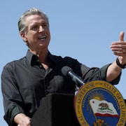 Un homme parle devant un lutrin.