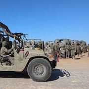 Des véhicules militaires et des soldats.