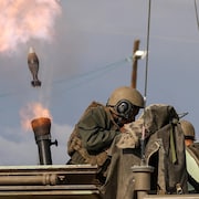 Des soldats tirent sur un char.