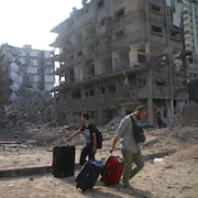 Des Palestiniens évacuent leurs maisons après des frappes aériennes israéliennes à Gaza.