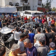 Des Palestiniens inspectent la carcasse d'une voiture visée par un bombardement israélien, faisant des victimes, à Deir al-Balah dans le centre de la bande de Gaza le 4 juin 2024.