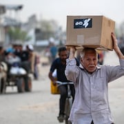 Un homme transporte du matériel de secours fourni par la Fondation humanitaire de Gaza.