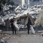 Des Palestiniens déplacés de leurs foyers à la suite des raids israéliens du 13 octobre 2023 dans la ville de Gaza. Israël a établi un siège de la bande Gaza et a lancé des frappes aériennes de manière soutenue, qui ont tué au moins 1 400 personnes et plus de 300 000 personnes déplacées, après une attaque à grande échelle du Hamas.