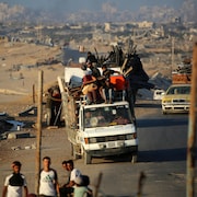Des Palestiniens fuyant vers le sud, transportant leurs biens dans un camion, sur la route côtière près du camp de réfugiés de Nousseirat, dans le centre de la bande de Gaza, le 5 septembre 2025.