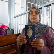 Une femme tient un carnet bleu. 