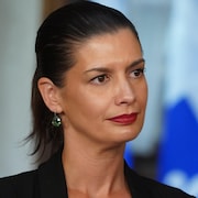 Geneviève Guilbault devant un drapeau du Québec.
