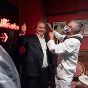 Un employé portant un masque sanitaire inspecte la statue de l'acteur dans le musée. 