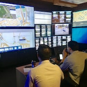 Deux employés scrutent les écrans du centre de gestion de la mobilité intelligente.