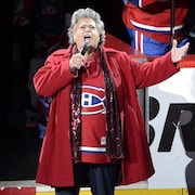 Ginette Reno porte le chandail de l'&eacute;quipe et chante sur la glace.