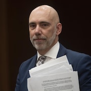 Le directeur parlementaire du budget, Yves Giroux tient des documents
