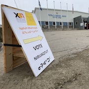 Une pancarte avec une flèche pointe vers l'entrée d'un bureau de vote d'Iqaluit lors des élections territoriales du lundi 25 octobre 2021.