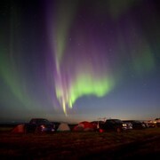 Une aurore boréale surplombe un camp de résidents de Yellowknife évacués à High Level, en Alberta, le jeudi 17 août 2023.