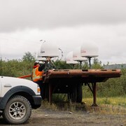 Un employé de l'entreprise Northwestel ajuste une antenne posée sur une remorque sur une photo non datée.