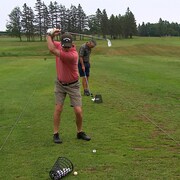 Un golfeur se prépare à frapper une balle de Golf avec son bâton.