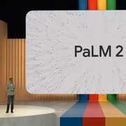 Un homme sur une scène géante et colorée présente un produit sur un écran géant. 