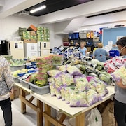 Des bénévoles dans le local où s'accumulent des centaines de produits.