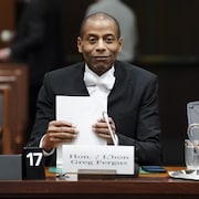 Greg Fergus tient des feuilles de papier devant un micro.