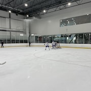 Des joueurs de hockey effectuent des exercices devant le filet.