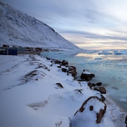 Village sur le bord de la rive d'une mer glacée.