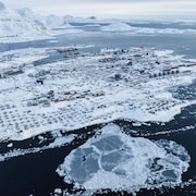 Des maisons recouvertes de neige sont visibles sur la côte d'un bras de mer de Nuuk, au Groenland, le vendredi 7 mars 2025.
