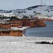 Des falaises de grès rouge érodées et enneigées.