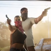 Un homme et une femme entrent dans un magasin avec des armes à feu dans les mains. 