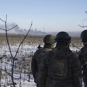 Des soldats ukrainiens regardent la fumée s'échapper de Soledar.