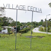 Une photo prise le 21 avril 2020 montre un panneau à l'entrée du village de Cecilia, près de Matoury, dans la banlieue de Cayenne, en Guyane française, lors d'un confinement au milieu de l'épidémie de COVID-19 (nouveau coronavirus).