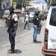 Des membres de la police nationale haïtienne patrouillent dans les rues.  