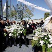 Le président haïtien Jovenel Moise et des représentants étrangers portent un bouquet de fleurs.