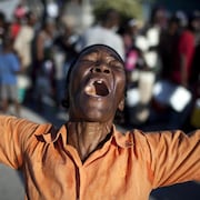 Une femme prie et chante dans une rue de Port-au-Prince, trois jours après le tremblement de terre du 12 janvier 2010.
