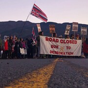 Des manifestants bloquent une route au pied de la plus haute montagne d’Hawaï, le Mauna Kea.