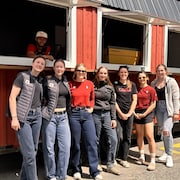 Hayden Mayeur dans son café mobile, avec des clients devant.
