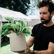 Lionel Mora tient une plante d'intérieur.