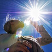 Une photo en contre-plongée d'une femme qui boit de l'eau.