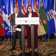 Heather Stefanson et François Legault se tiennent debout derrière un lutrin. 