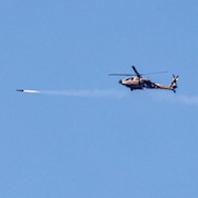 Un hélicoptère tire un missile.