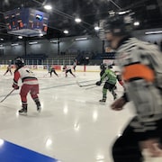Des joueurs de hockey et un arbitre sur la patinoire.