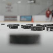 Des rondelles de hockey sur une patinoire intérieure.