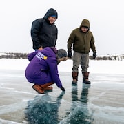 Trois personnes sur une route de glace sur un lac.